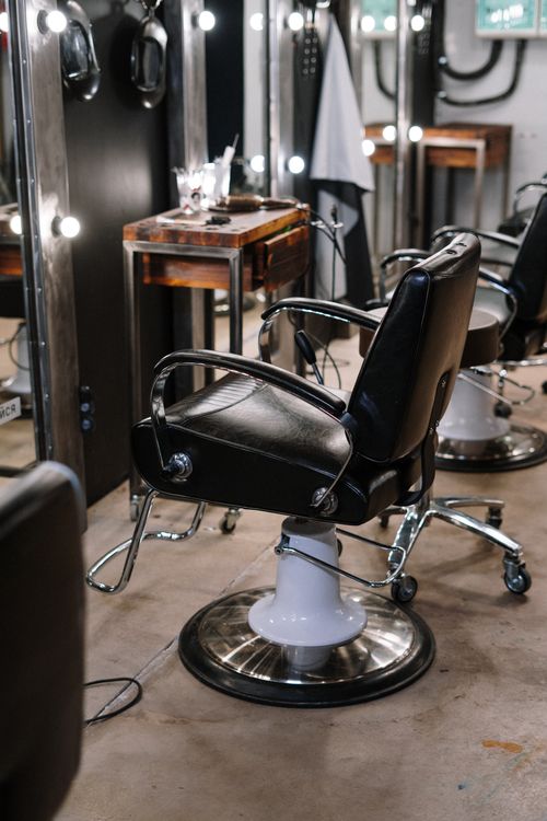 Cadeira e espelhos em uma barbearia, fotografia ilustrativa